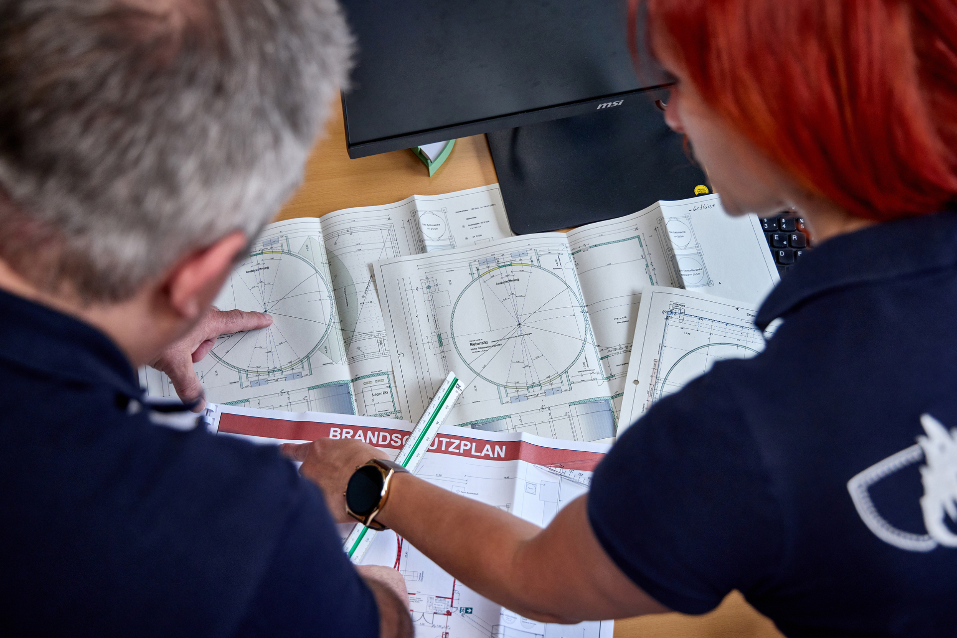Brandschutzingenieur prüft Grundriss und Brandschutznachweis am Arbeitsplatz – Greinwald Brandschutz