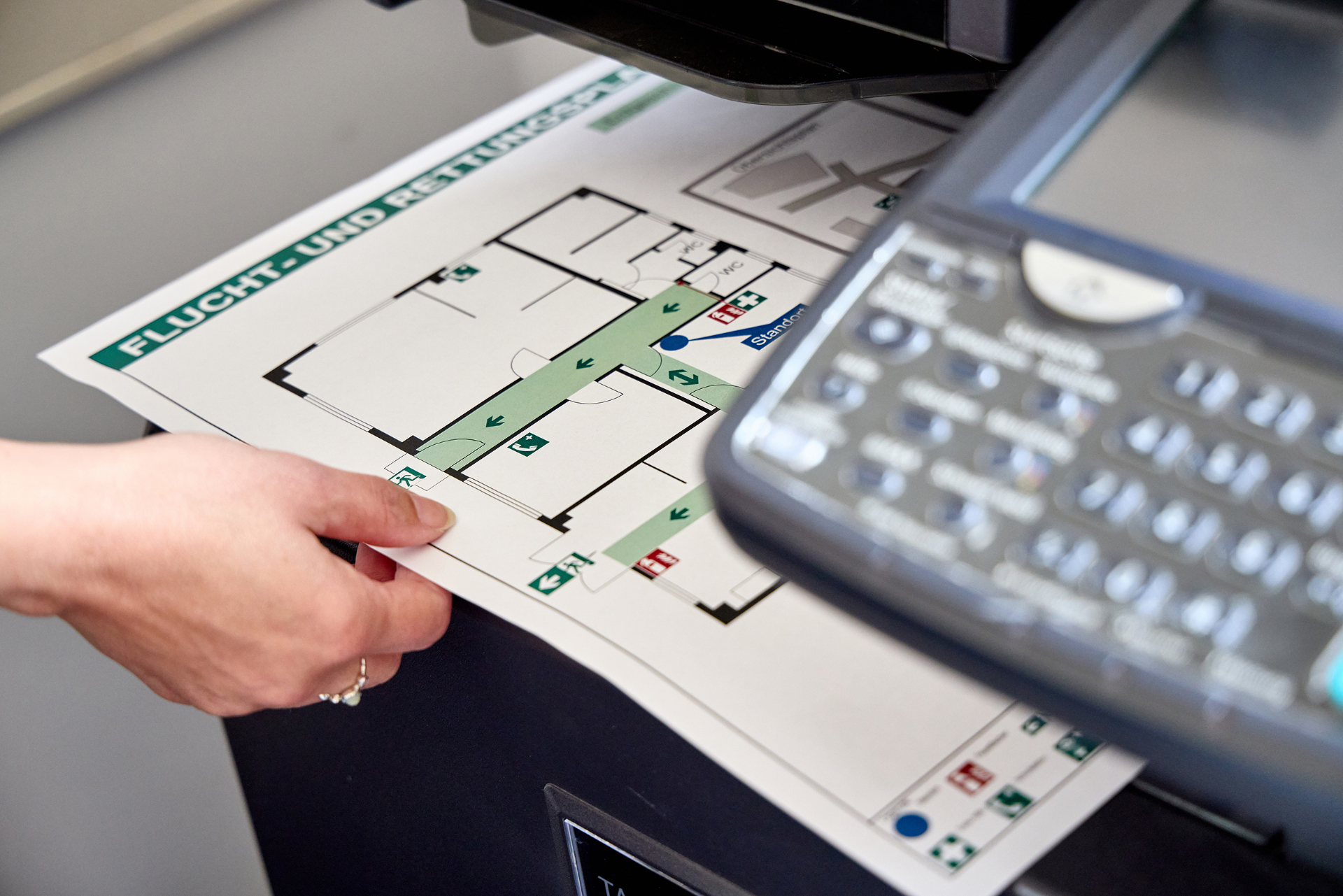 Fertig gedruckter Flucht- und Rettungsplan wird am Drucker entnommen